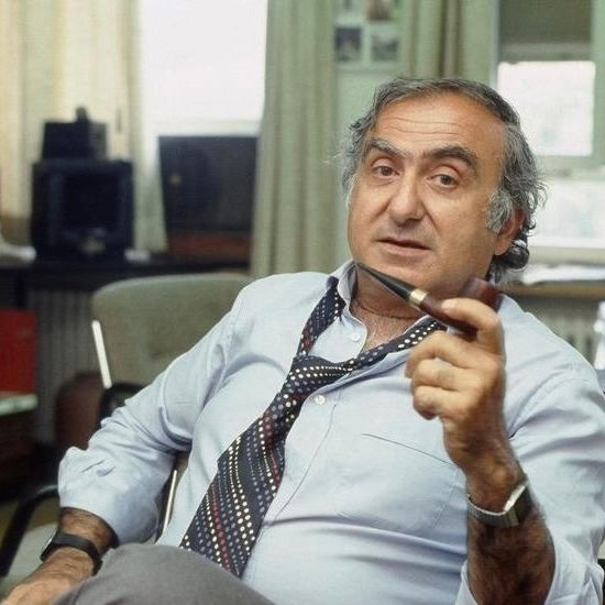 nicolas George Hayek Founder of Swatch sitting in Chair and smoking Pipe